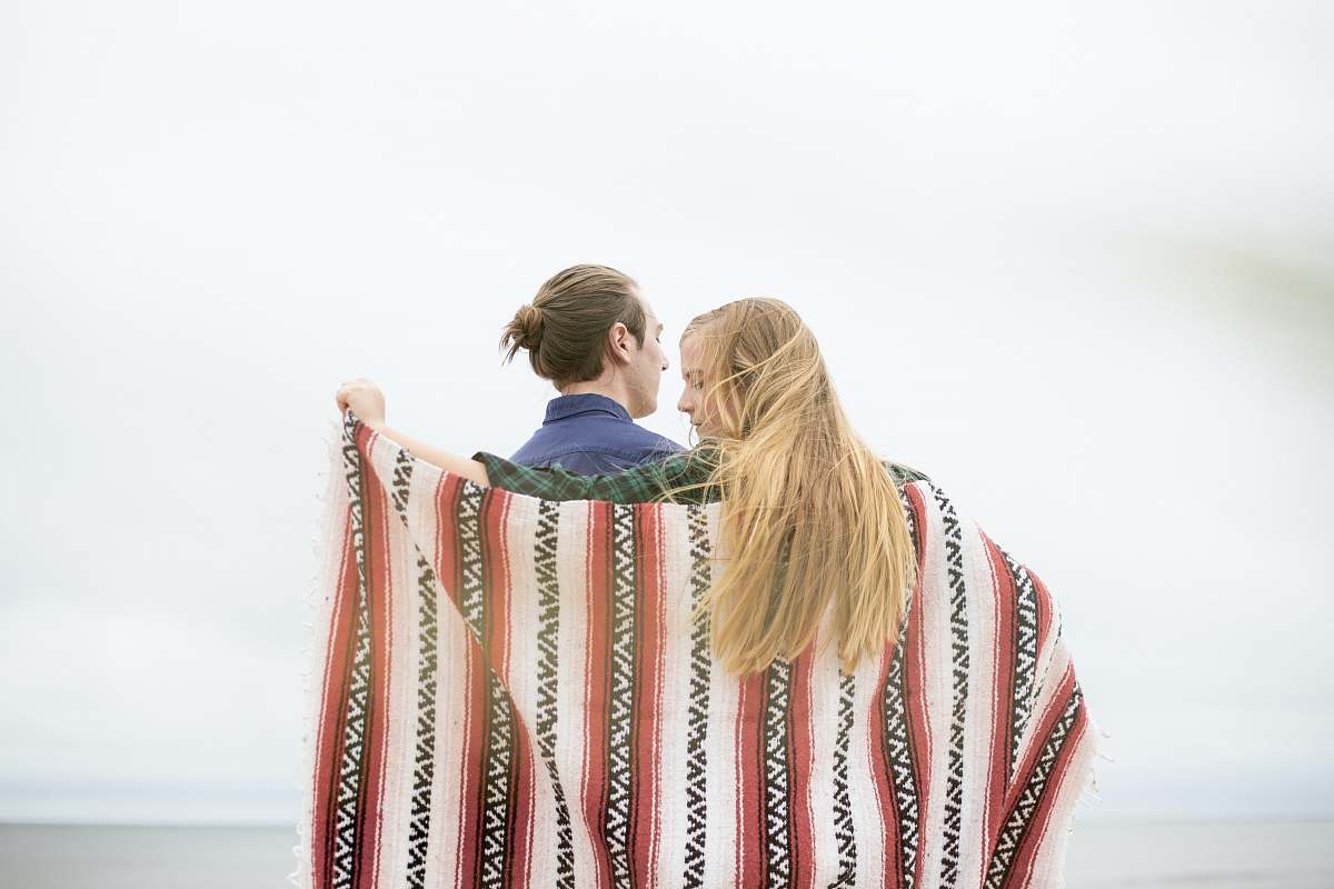 grand haven woman holding red and black aztec textile blonde